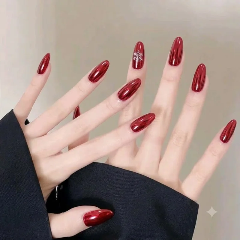 Red chrome manicure with a subtle white snowflake accent nail for winter events and holidays