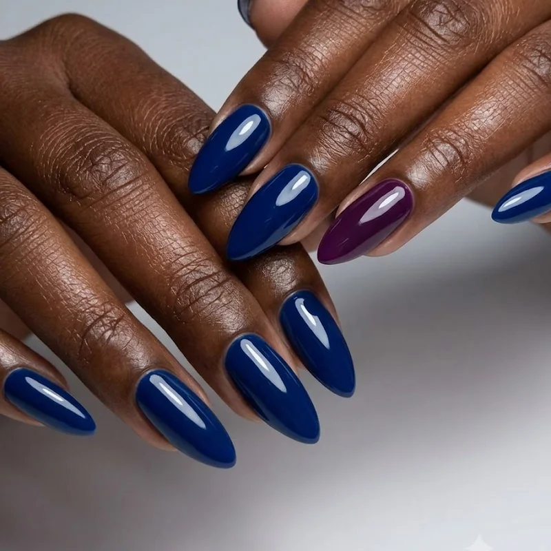 Rich jewel-toned winter nails for dark skin against a moody winter backdrop with soft light