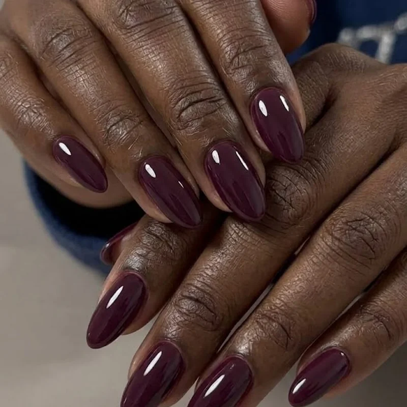 Short almond shaped winter nail color for dark skin in a deep saturated winter shade