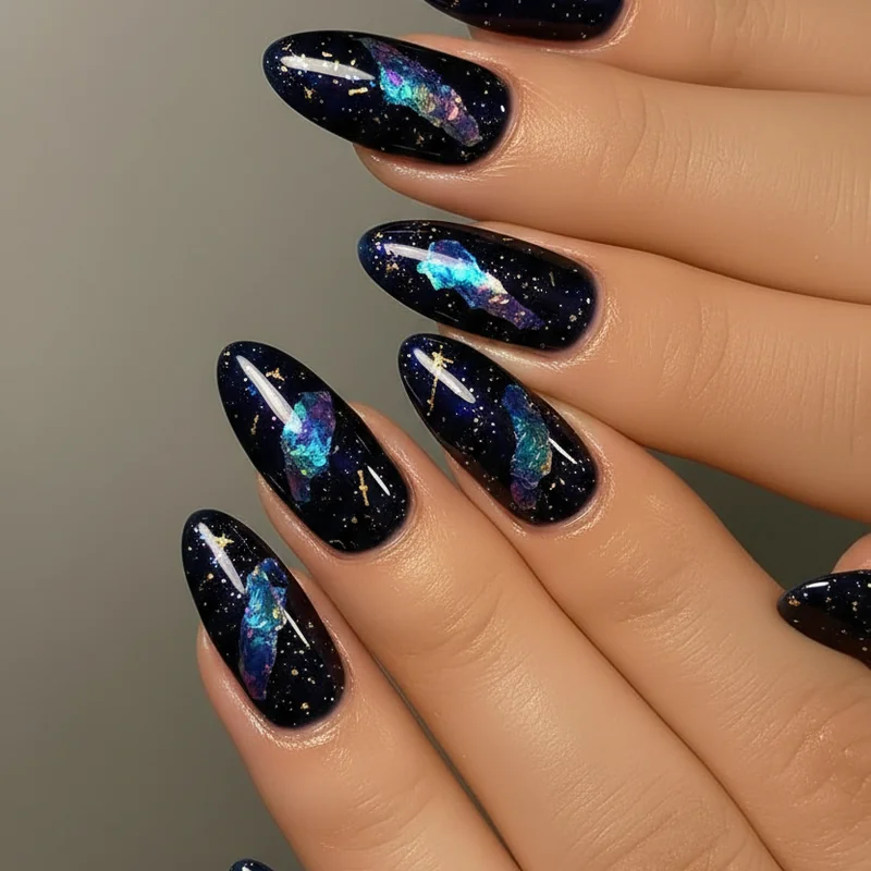 Dark moody galaxy celestial nails with velvet midnight base gold star nail art and iridescent foil fragment details for night sky effect
