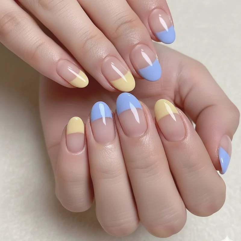 Gemini dual tone split French tip nails showing butter yellow and periwinkle blue colour pairing on short square nails close up