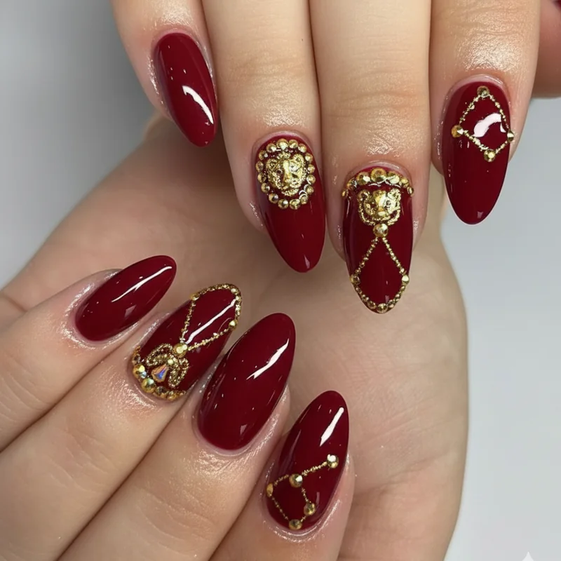 Leo birthday nails featuring ruby red gel base with gold chrome accent nails and rhinestone details for July Leo birthday celebration set