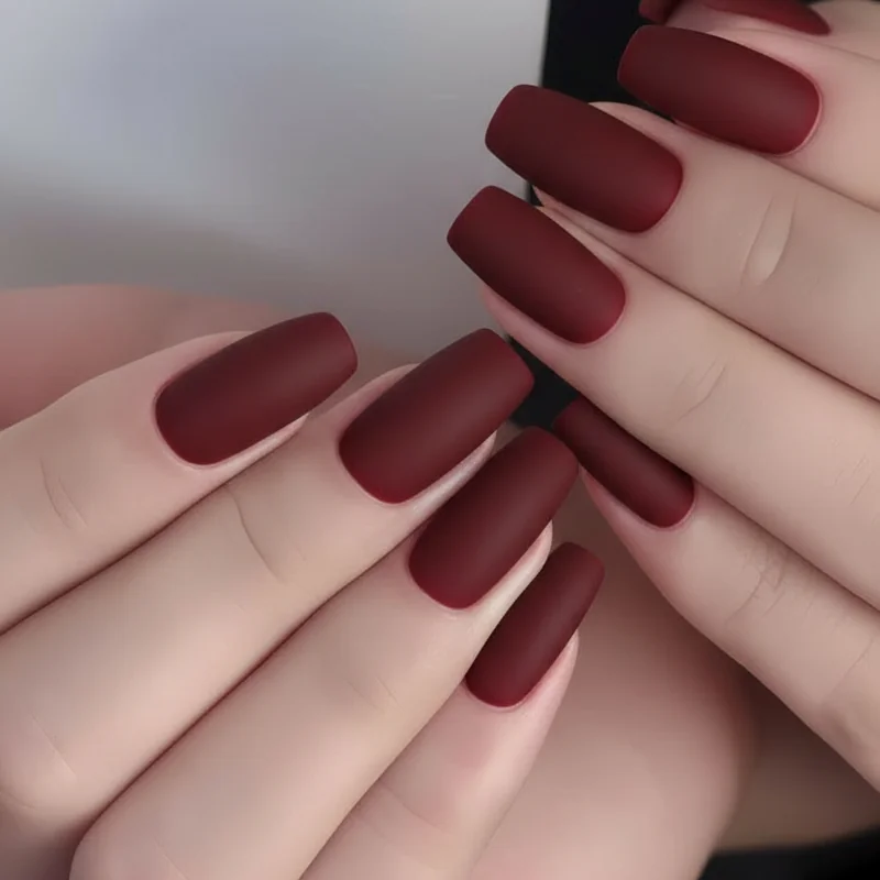Minimalist Scorpio nails in velvet matte oxblood on short square shape showing quiet menace aesthetic with no embellishment