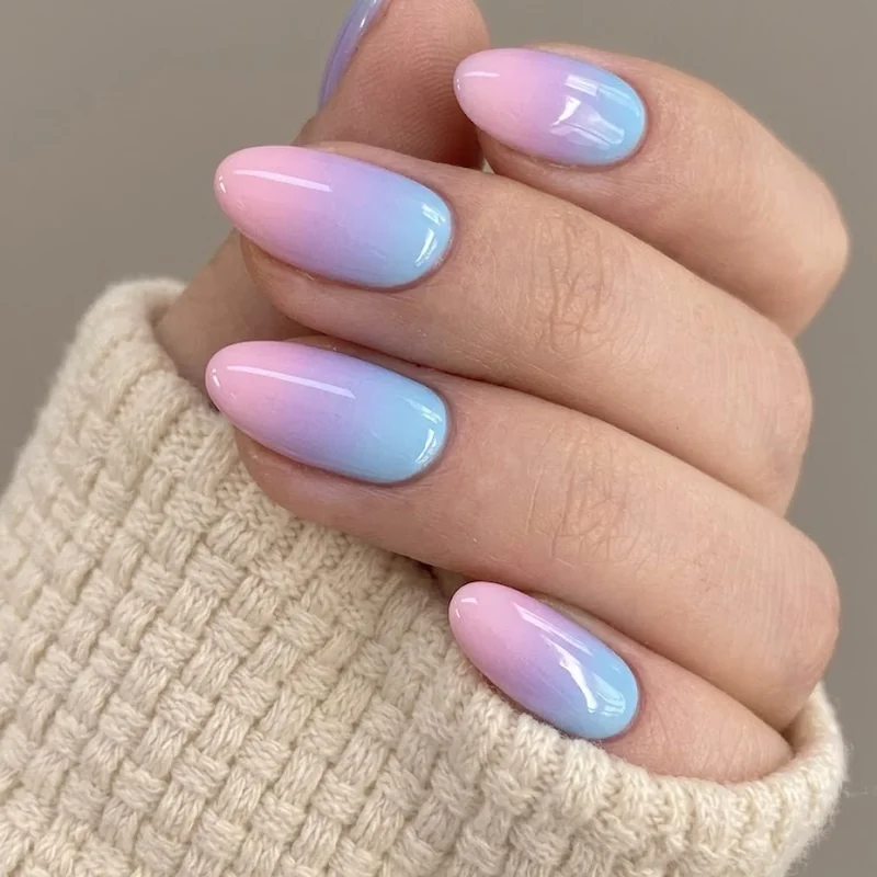 Bisexual ombre nails blending pink, purple, and blue in a glossy gradient