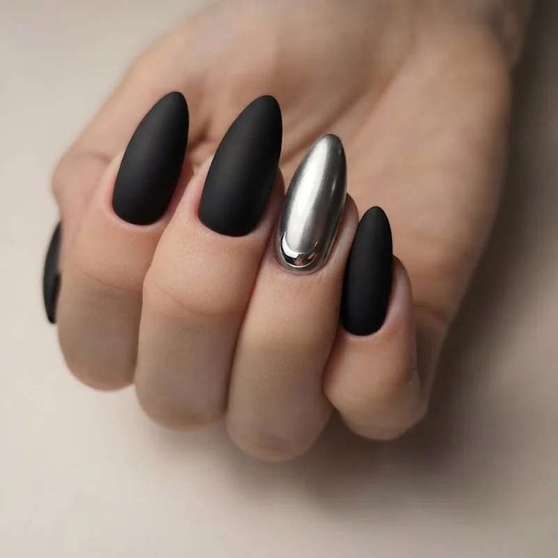 Matte black halloween nails with a solid moody manicure and a single silver moon accent nail