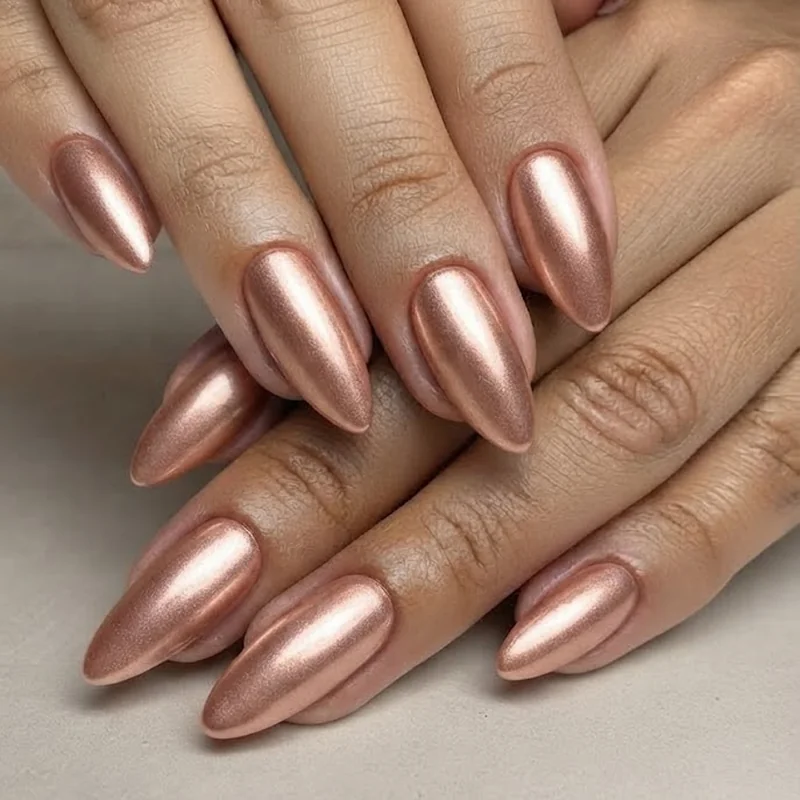 Rose gold chrome almond nails with warm metallic shimmer finish