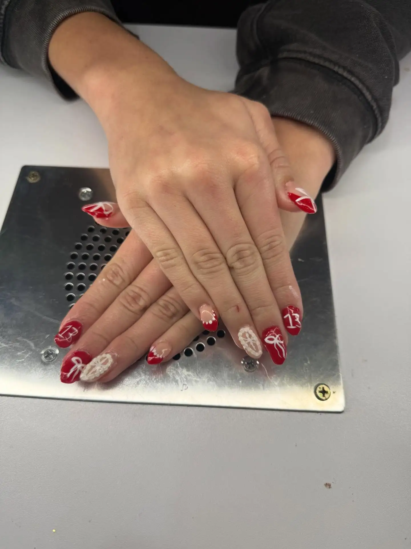 Red lace bow detailed custom almond gel nail set by Peyton Combs Shelby Township Michigan nail tech intricate hand painted art