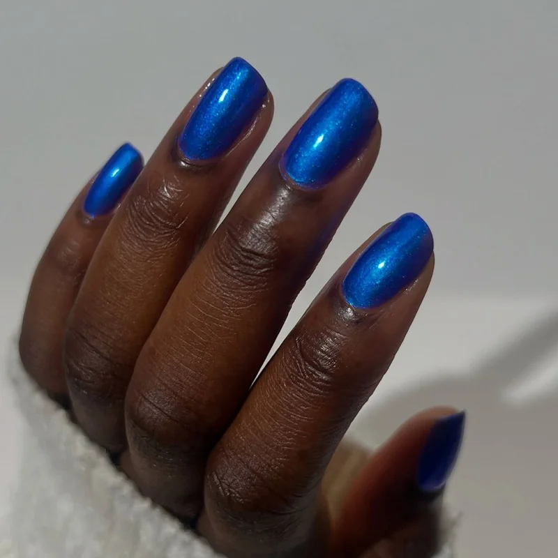 Fair skin tone wearing sapphire blue jewel tone nail polish showing vibrant contrast and elegance