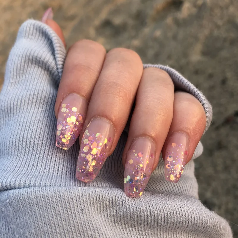 Makeup sponge creating ombre gradient and glitter nail effects showing blending technique for home DIY