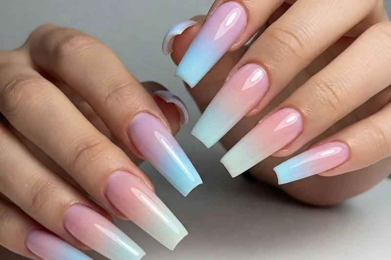 Using makeup sponge to create ombre gradient nail effect by dabbing multiple polish colors for smooth blended design