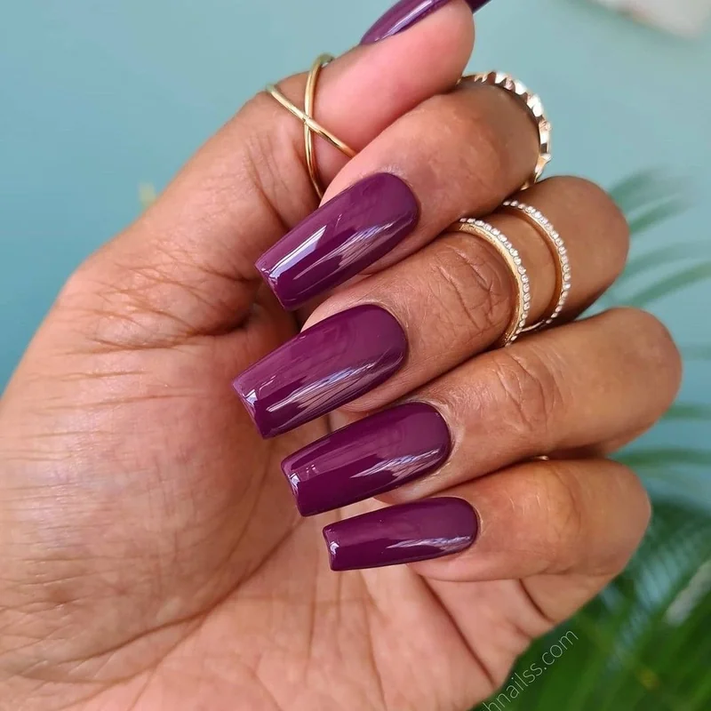 Medium cool undertone skin wearing rich plum magenta bold statement nail colors showing dimension