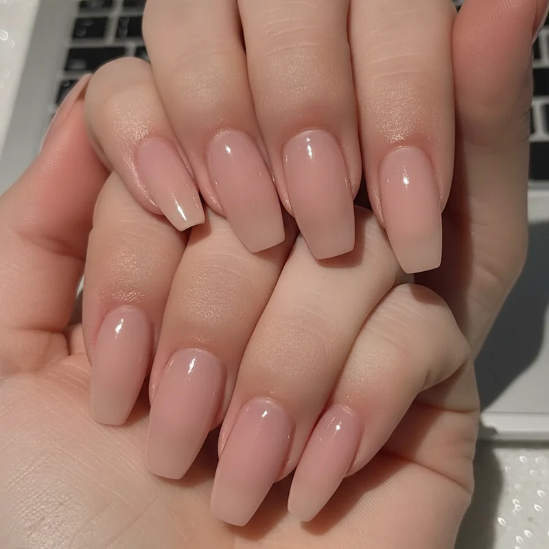 Modern working woman typing on laptop with short squoval professional nails office desk work setting
