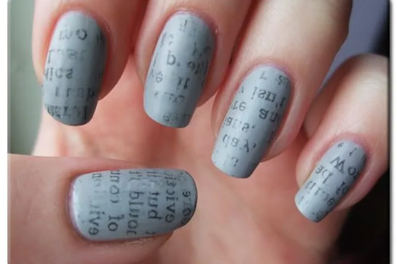 Newspaper print transfer nail art technique using rubbing alcohol to transfer text and images onto painted nail surface