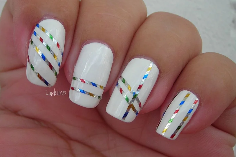 Creating perfect geometric stripe nail art using scotch tape as guide for clean lines and professional looking designs