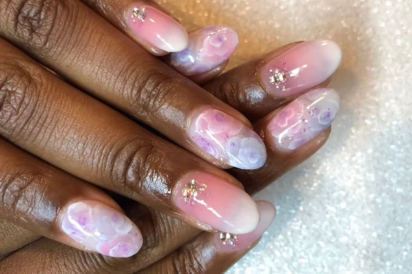 Spring 2025 minimalist cherry blossom nail art on soft pink base with white petals delicate floral design