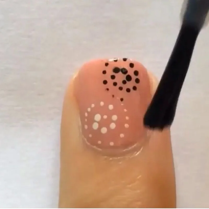 Close up of toothpick dotting technique for beginner nail art showing proper tool angle and pressure