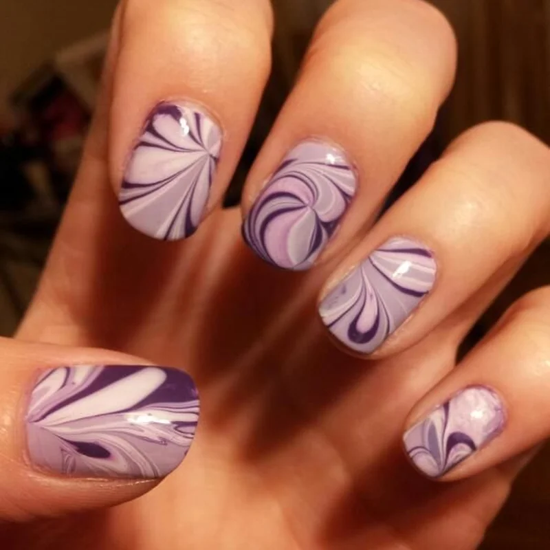 Water marble nail art result showing psychedelic swirl finish unique pattern from home technique