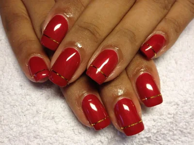 Elegant Christmas 2025 nails in burgundy with gold pinstripe accent and pearl details for festive holiday look