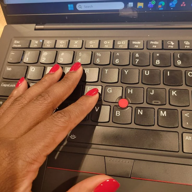 Modern working woman typing on laptop with short squoval professional nails office desk work setting