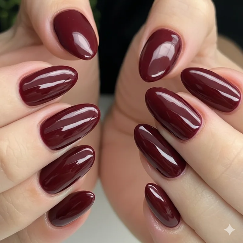 Dark burgundy oxblood nail on squoval shape with high gloss finish showing deep professional office manicure design in 2026