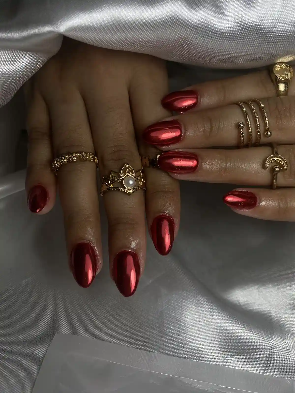 Burgundy chrome short nails with metallic red mirror finish creating unique winter manicure perfect for modern holiday party style