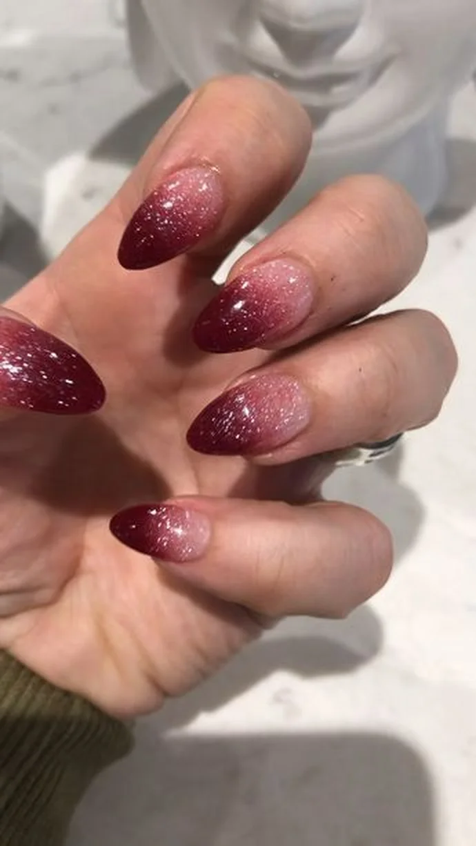 Burgundy glitter gradient nails with sparkly ombre effect creating festive winter party manicure perfect for holiday celebration 2025