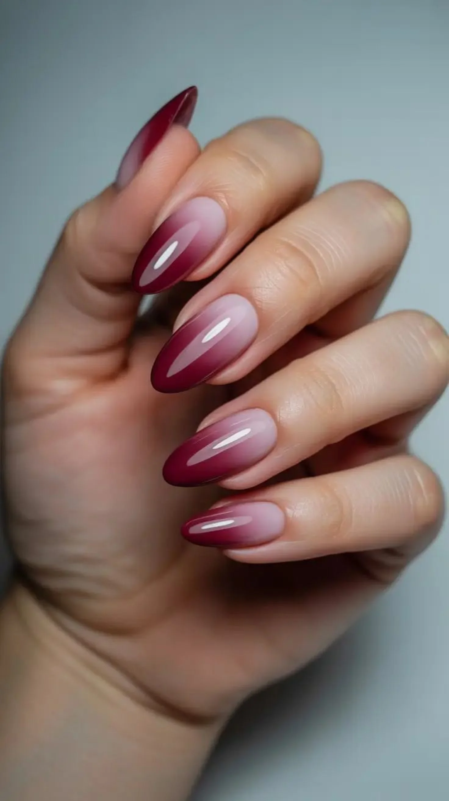Burgundy to nude ombre nails with gradient transition creating elegant winter manicure perfect for sophisticated neutral style 2025
