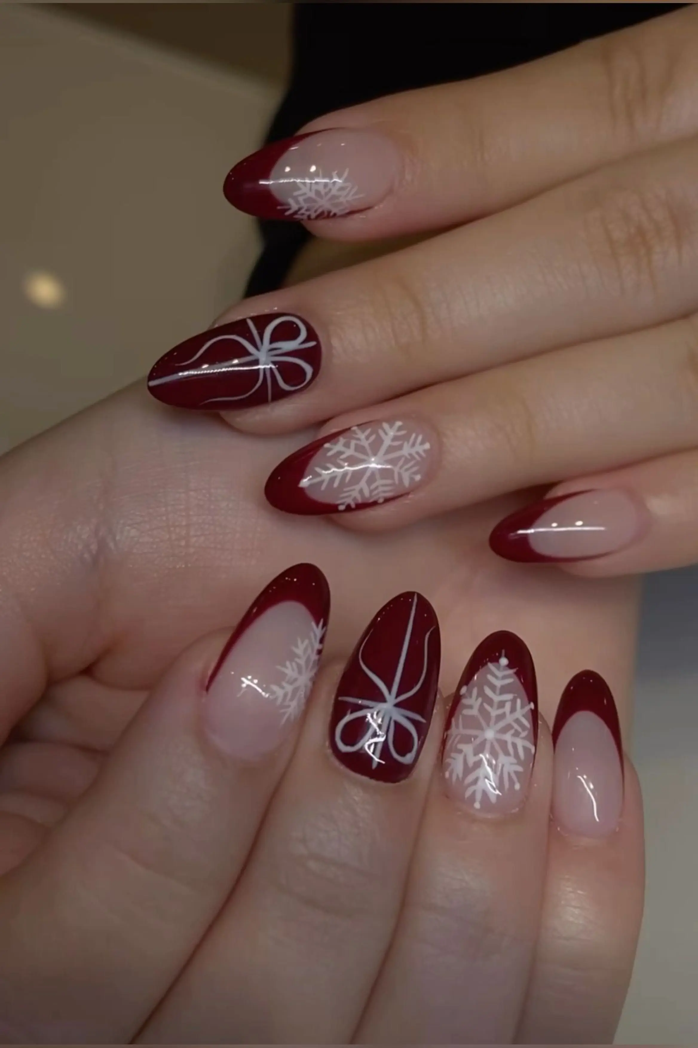 Cranberry burgundy almond nails with bright wine red creating festive winter nail art perfect for Christmas holiday season design