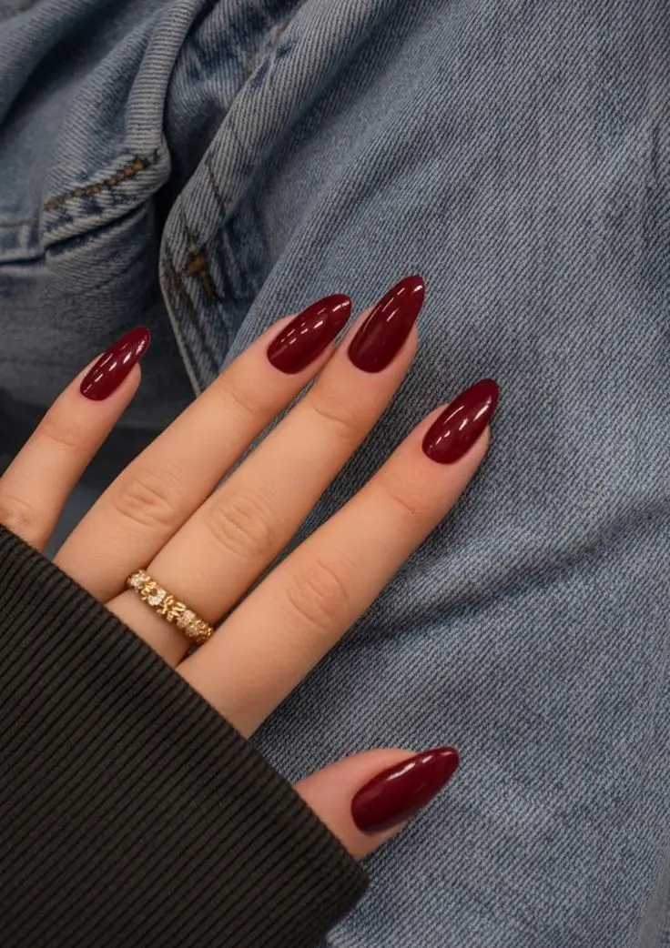 Deep burgundy wine red almond nails with glossy finish creating classic elegant winter manicure perfect for holiday season 2025