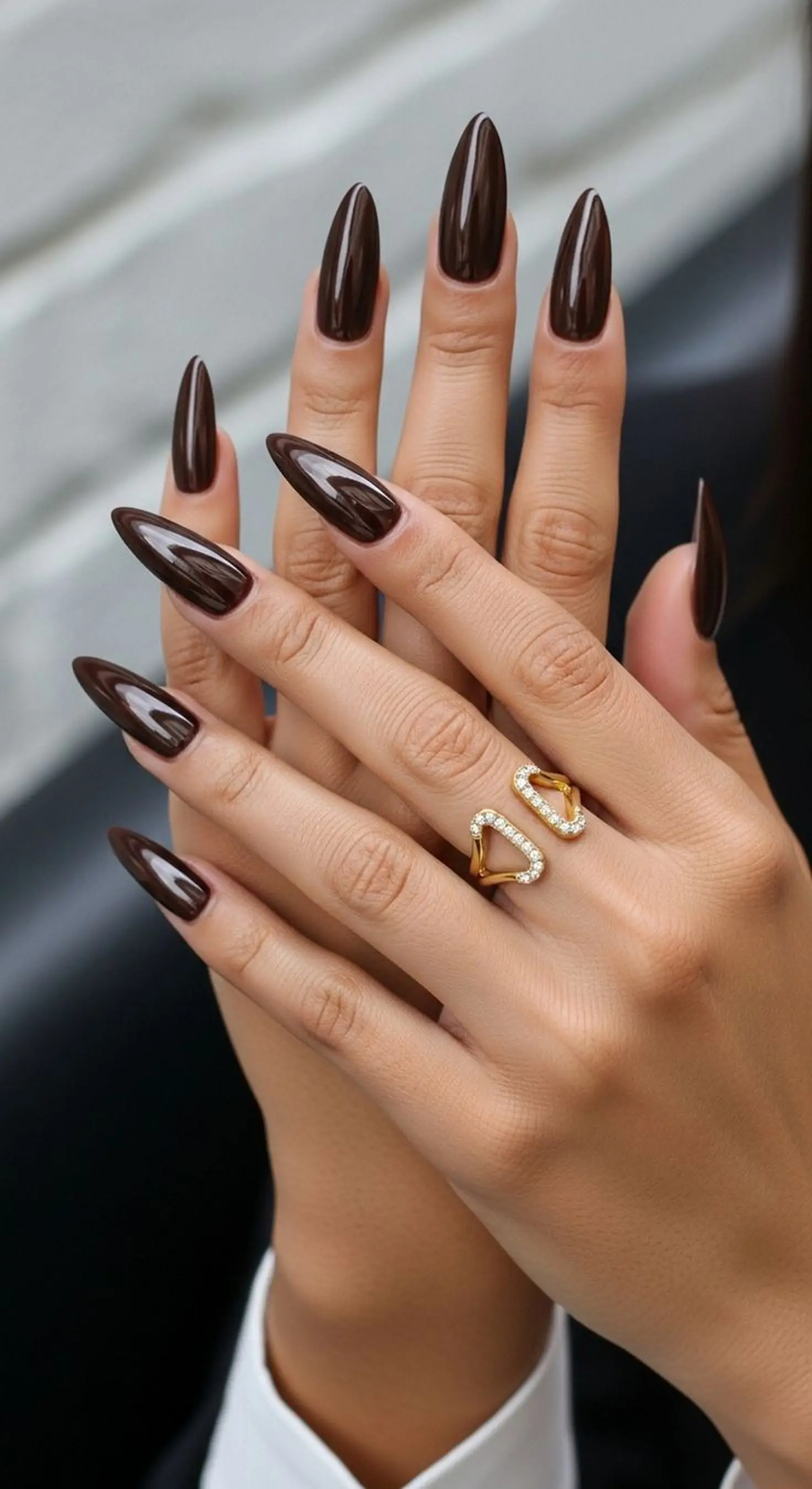 Coffee brown glossy almond nails with shiny warm finish creating trendy Pantone winter manicure style perfect for cozy aesthetic
