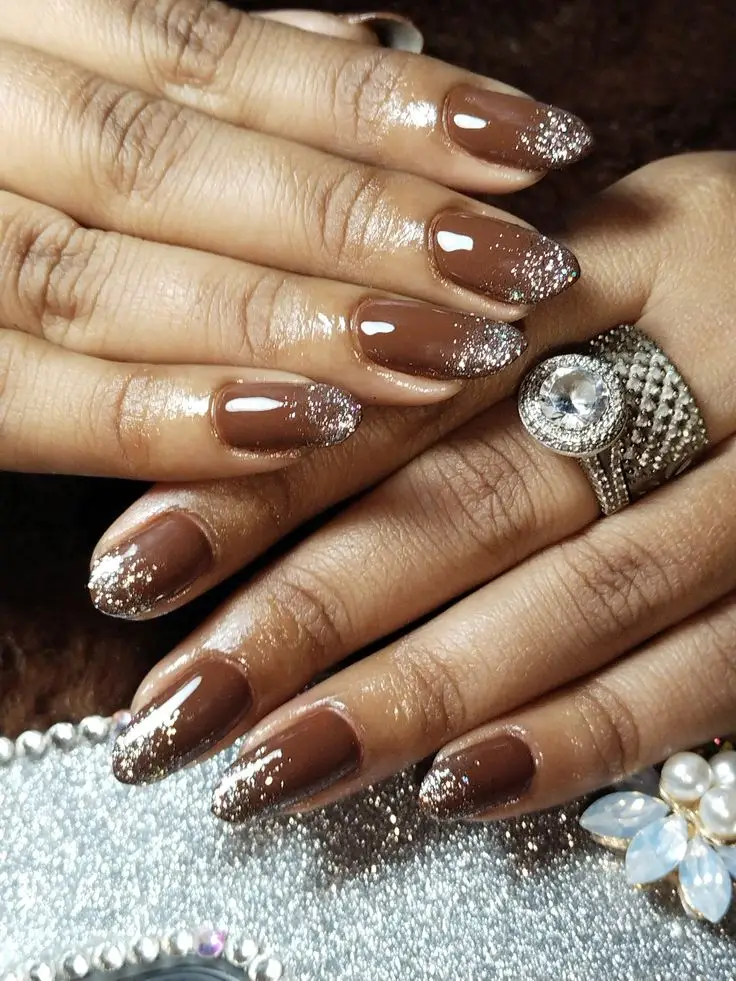 Mocha brown glitter accent nails creating sparkly Pantone 2025 winter party manicure perfect for festive holiday season celebrations
