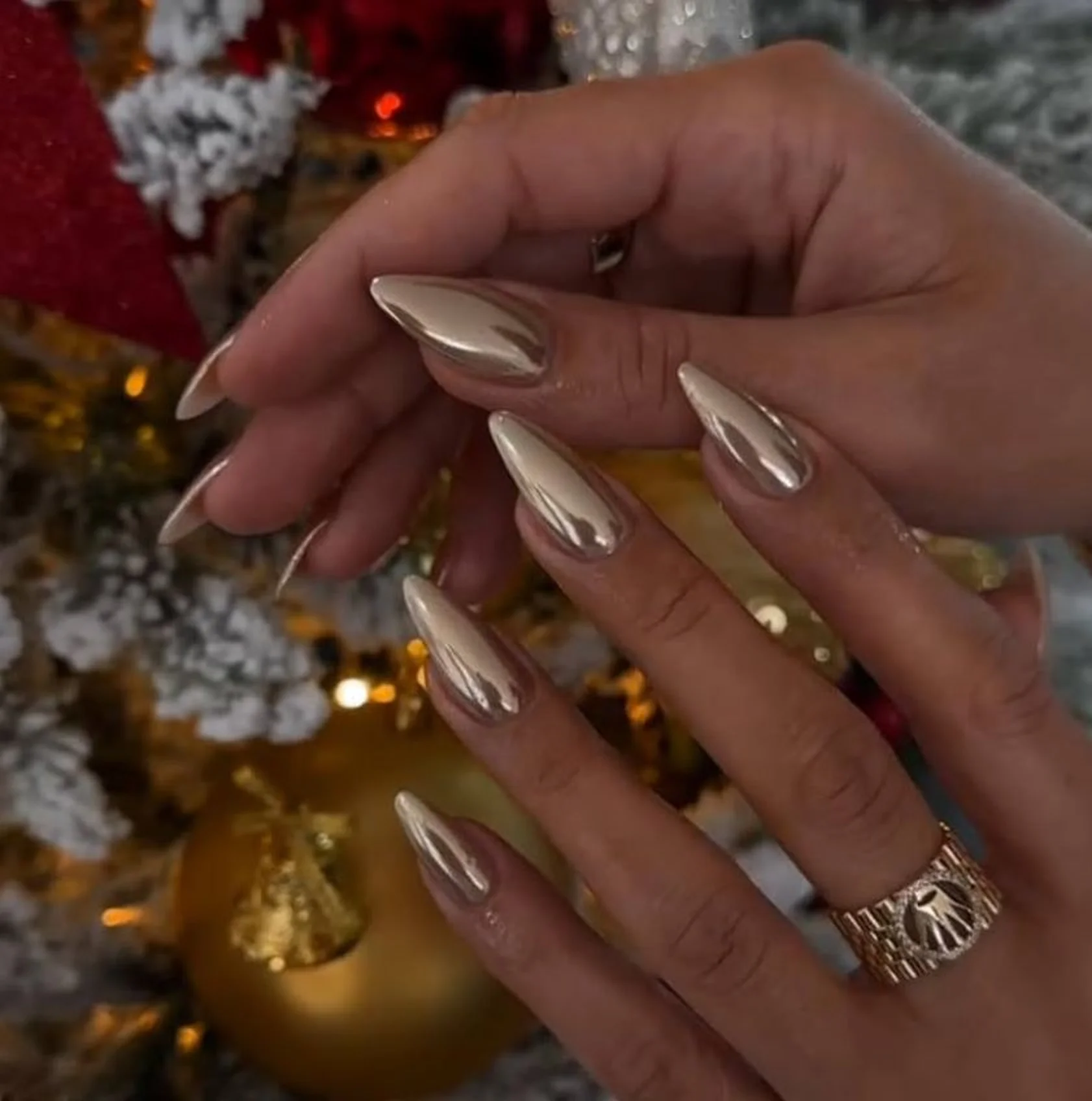 Champagne chrome almond nails with elegant subtle metallic finish creating sophisticated holiday winter manicure perfect for formal events