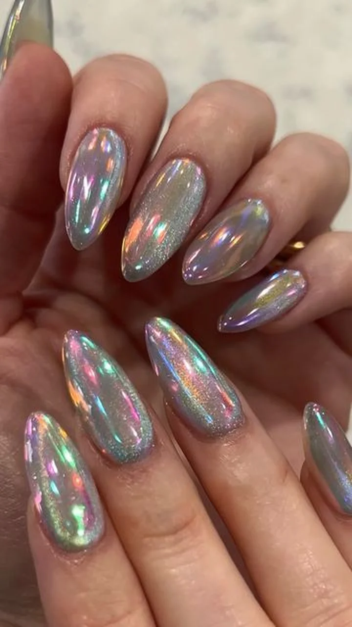 Holographic aurora chrome almond nails with iridescent color shift effect creating rainbow metallic winter manicure 2025