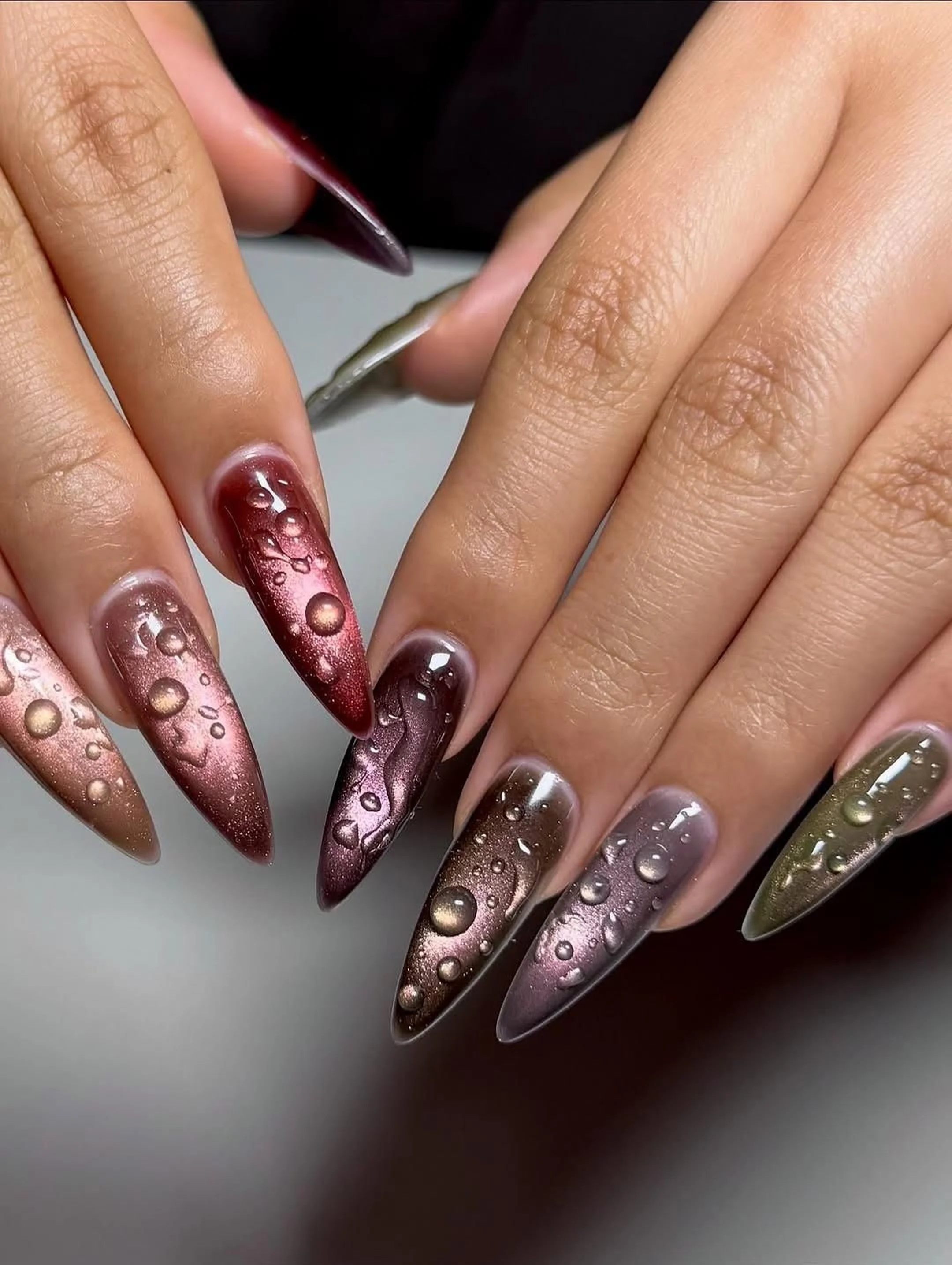 Magnetic chrome gradient nails with cat eye effect creating dimensional metallic winter manicure with light catching finish