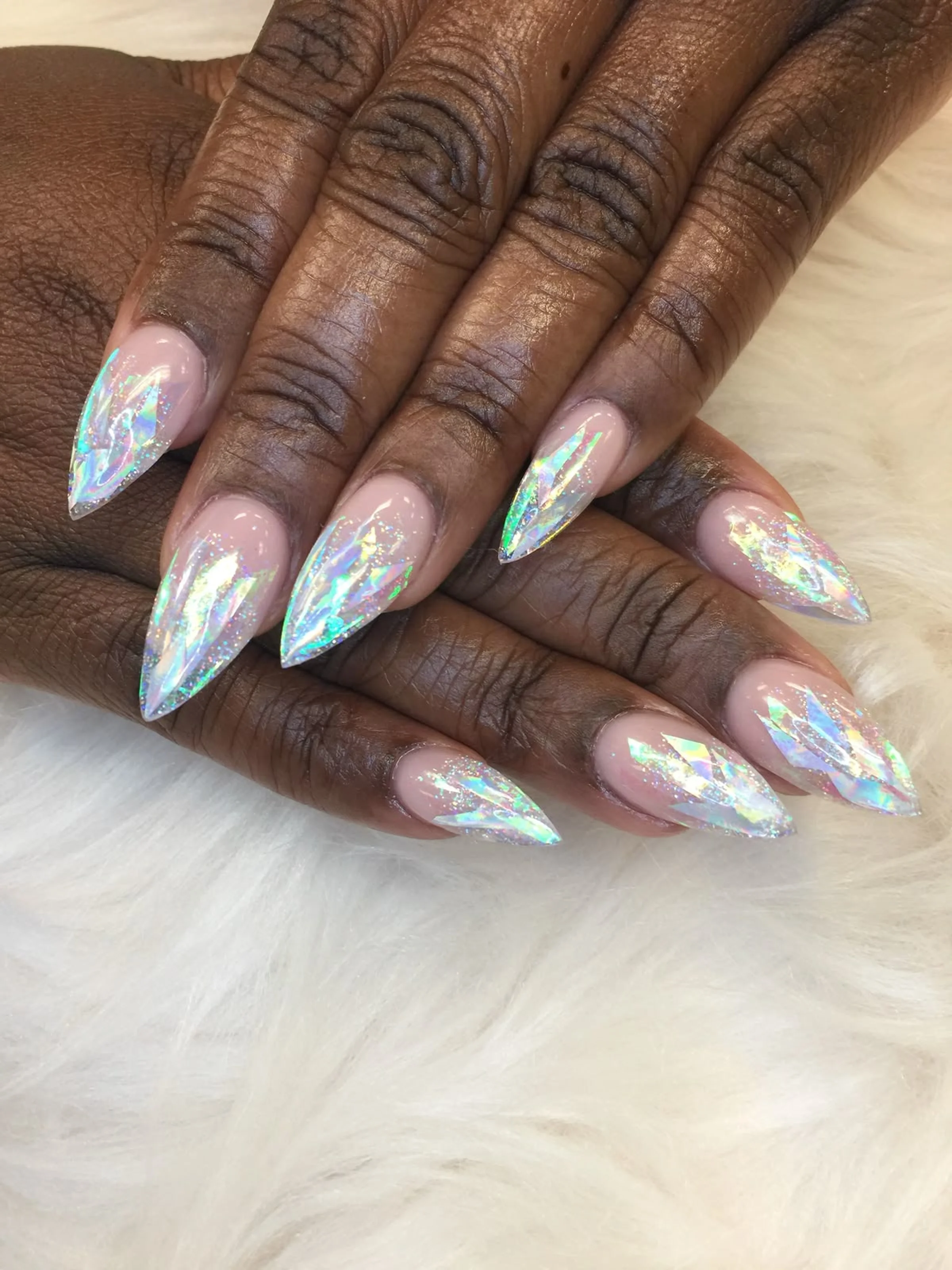 Rainbow chrome glitter nails with holographic shimmer creating bold festive winter party manicure perfect for New Year celebrations