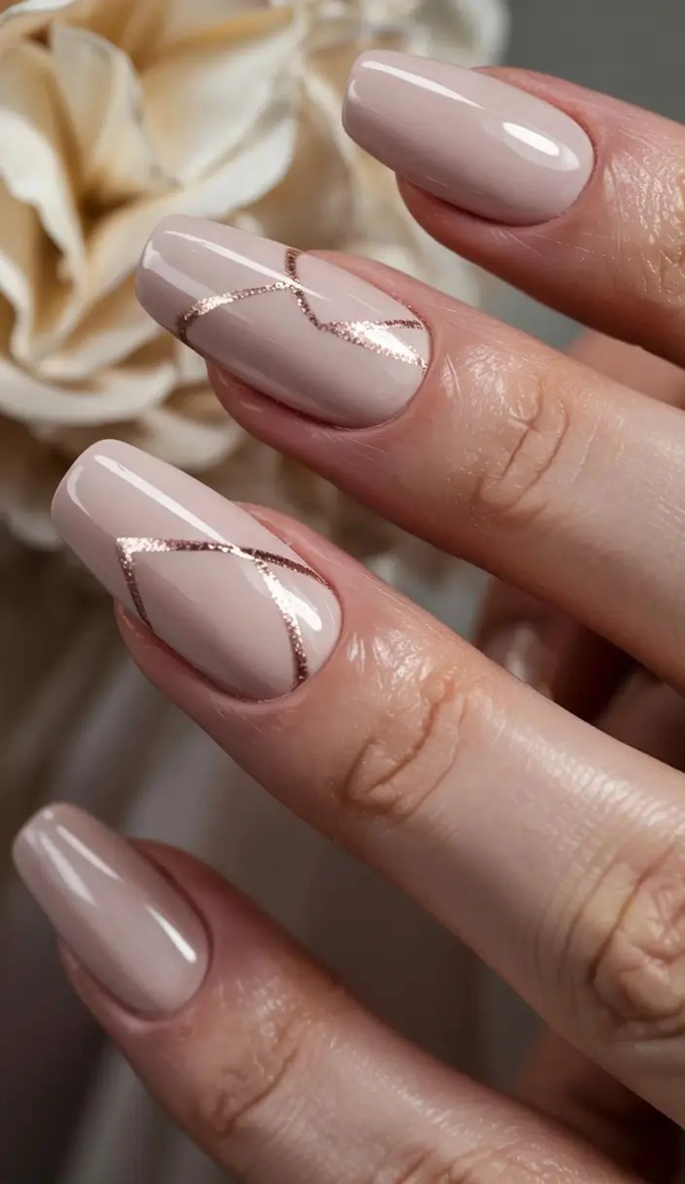 Nude nails with rose gold thin accent line creating delicate modern minimalist winter manicure design perfect for elegant professional style