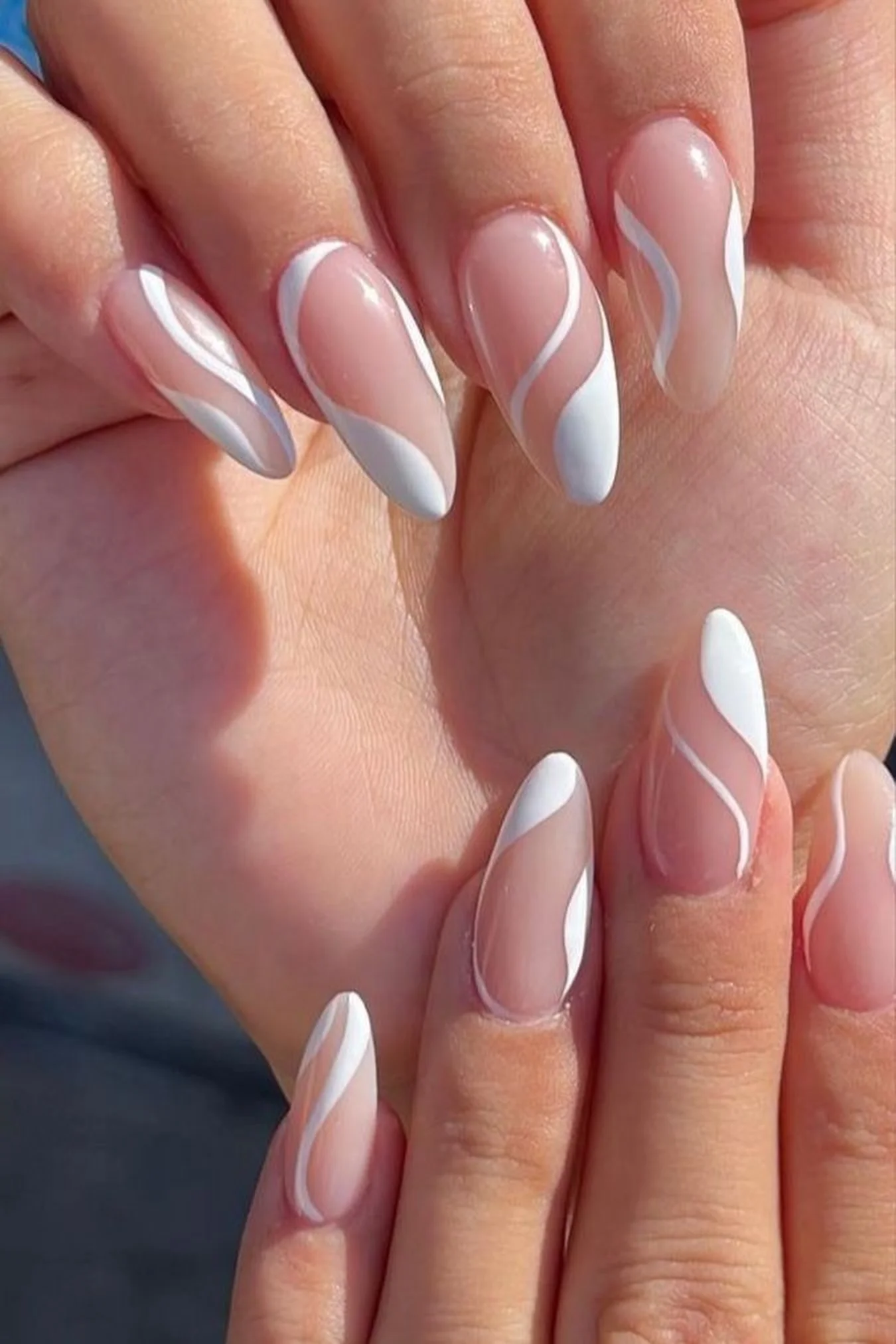 White negative space almond nails creating modern clean minimalist winter nail art design perfect for contemporary professional manicure