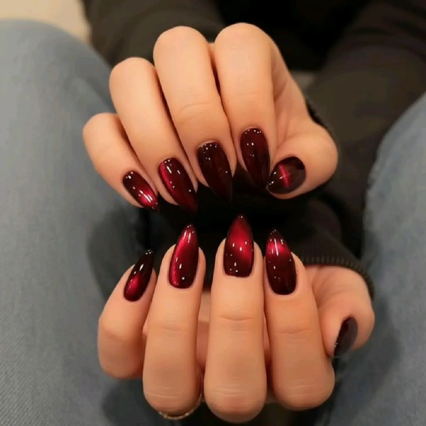Magnetic burgundy velvet nails with dimensional wine red finish creating stunning cat eye winter manicure perfect for elegant events